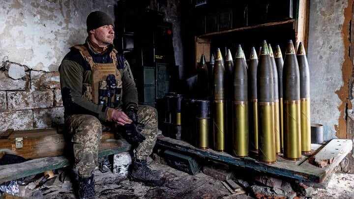 A Ukrainian soldier next to 155 mm artillery shells.