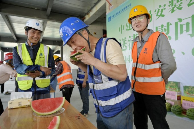 Los trabajadores de la construcción en Beijing comen sandía para refrescarse el 16 de junio. Foto: Xinhua