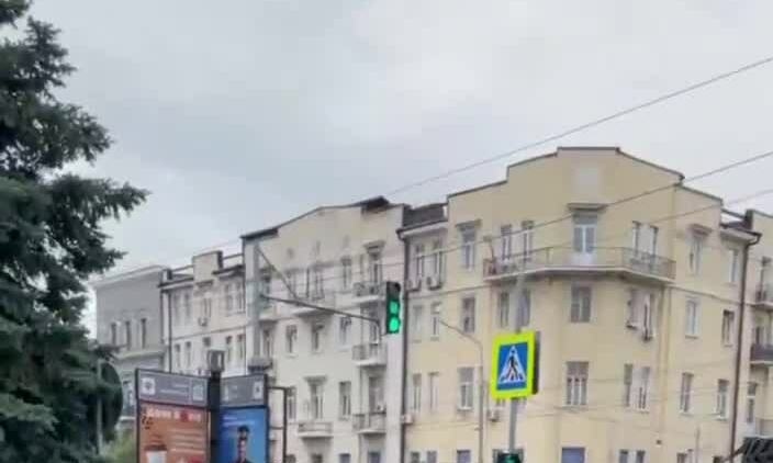 ロシアの清掃員がワグナー装甲車の横で静かに道路を掃除している