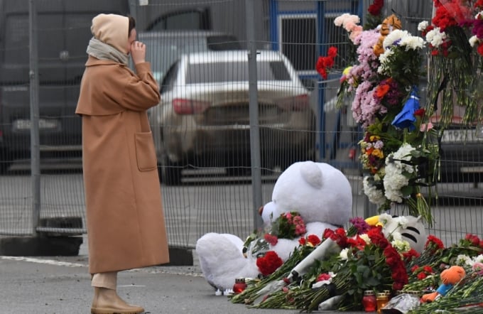 Una mujer llora mientras lamenta el fallecimiento de las víctimas del tiroteo, fuera de las barricadas que rodean el lugar. Foto: AFP