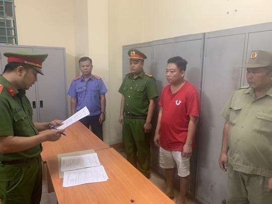 Police read the decision to prosecute Vo Minh Dien (red shirt).