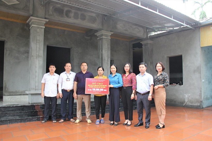 El presidente del Sindicato de Educación de Vinh Phuc (con camisa azul) entregó dinero para apoyar la construcción de la casa de la maestra Nguyen Thi Huyen.