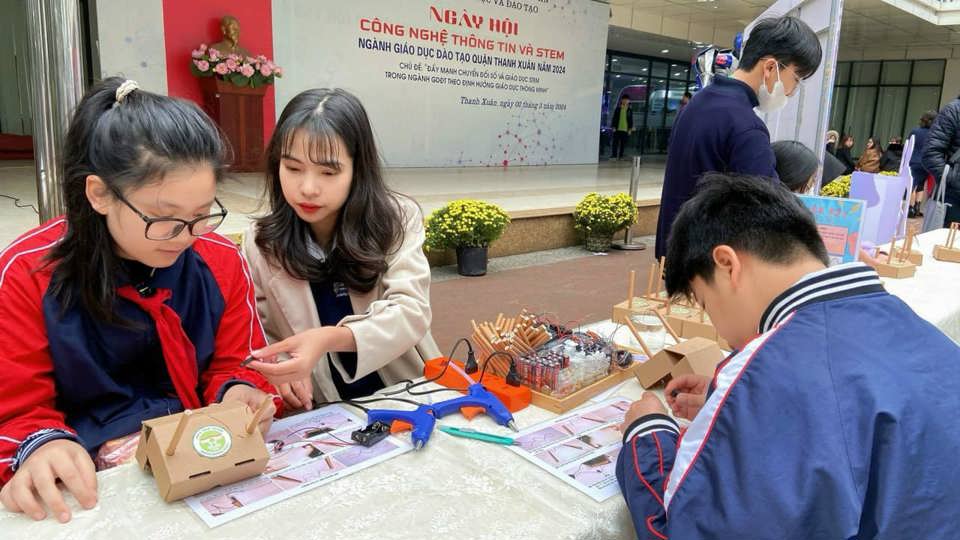 The teacher guides students in the IT festival.