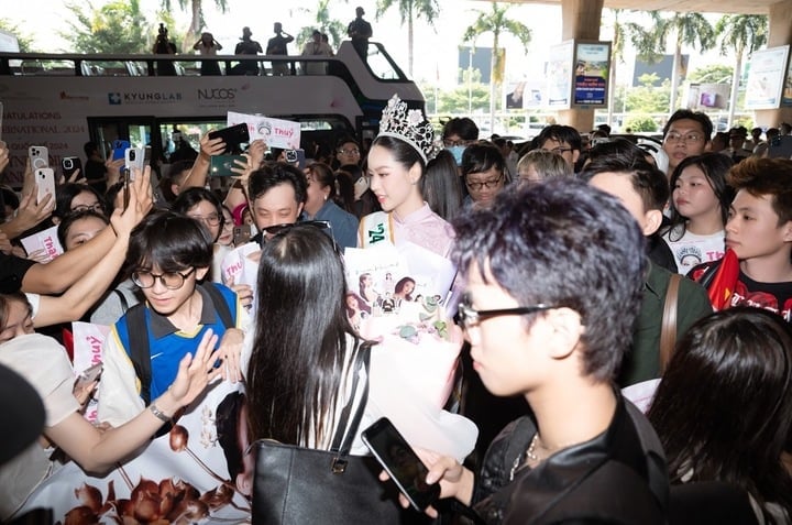 Diện trang phục áo dài truyền thống và đội vương miện Miss International 2024, cô đã nhận được sự chào đón nồng nhiệt từ hàng trăm người hâm mộ, gia đình và bạn bè.