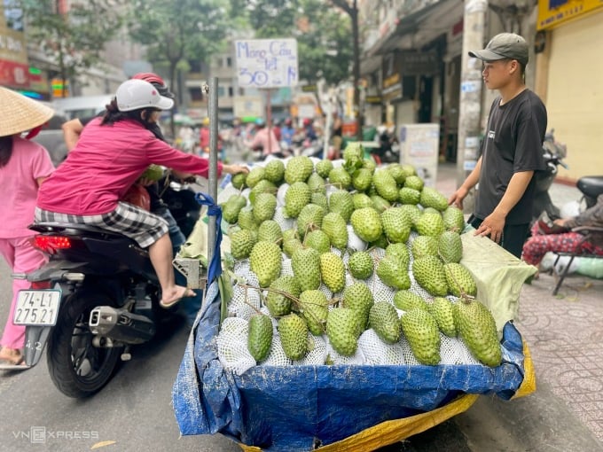 Tiểu thương bán mãng cầu tại chợ Hoà Bình, quận 5, TP HCM nói: Mỗi kg mãng cầu hiện chỉ 60.000 đồng, rẻ hơn 20.000-30.000 đồng so với Tết năm ngoái, mà bán vẫn rất chậm. Ảnh: Quỳnh Trang