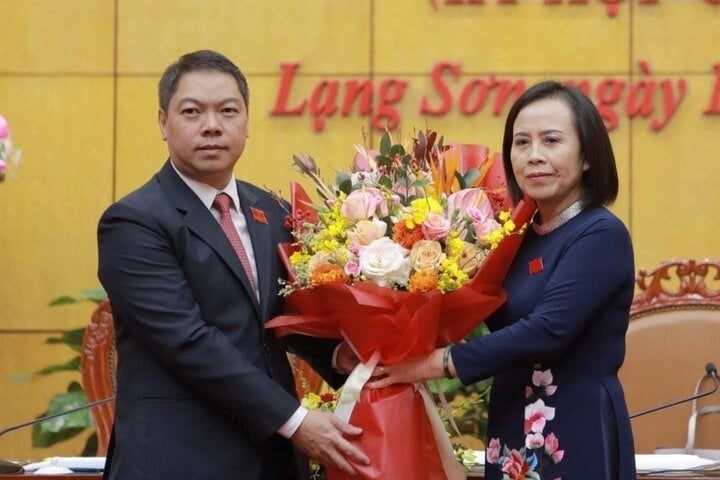 Ms. Doan Thi Hau - Chairwoman of Lang Son Provincial People's Council (right) presented flowers to congratulate the new Vice Chairman of the Provincial People's Committee Doan Thanh Son.