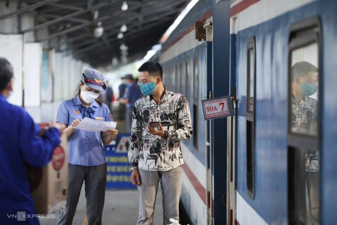 Le personnel ferroviaire vérifie les informations des passagers avant de monter à bord d'un train quittant la gare de Saigon le 13 octobre. Photo : Quynh Tran