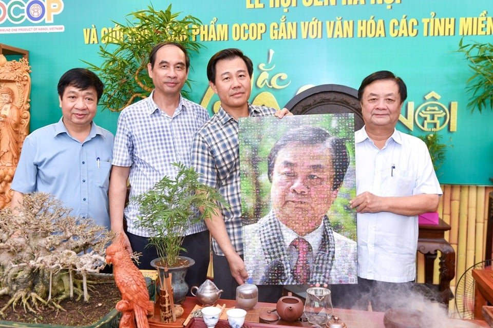 Director of Hanoi Department of Agriculture and Rural Development Nguyen Xuan Dai presented Minister of Agriculture and Rural Development Le Minh Hoan with a souvenir photo.