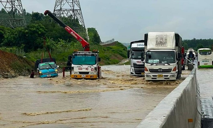 Xe cứu hộ đang kéo một xe tải bị nước cuốn trôi vào lề trên đoạn Cao tốc Dầu Giây - Phan Thiết ngập, sáng 29/7. Ảnh: Anh Thế