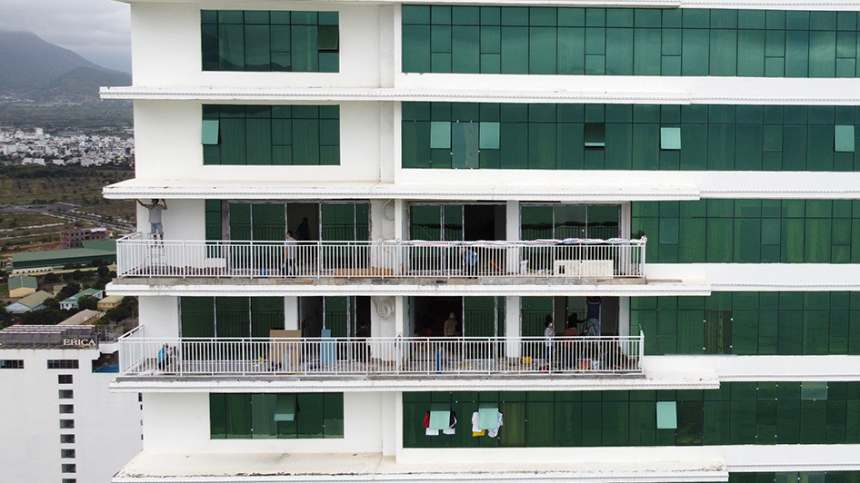 Trabajadores abren cristales para cambiar la función de siete apartamentos en los pisos 41 y 42 del edificio Muong Thanh, en Tran Phu 60. Foto: Trung Nhan