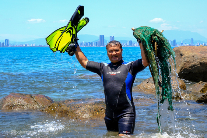 El Sr. Dao Dang Cong Trung, miembro fundador del grupo de buceo libre en Da Nang, con sus desechos recién sacados del mar. Foto: Nguyen Dong