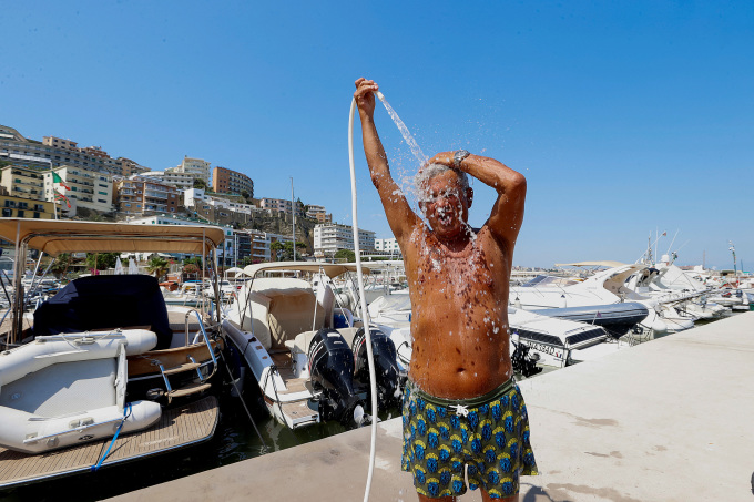 Un hombre se rocía agua sobre el cuerpo para refrescarse en Nápoles, Italia, el 10 de julio.