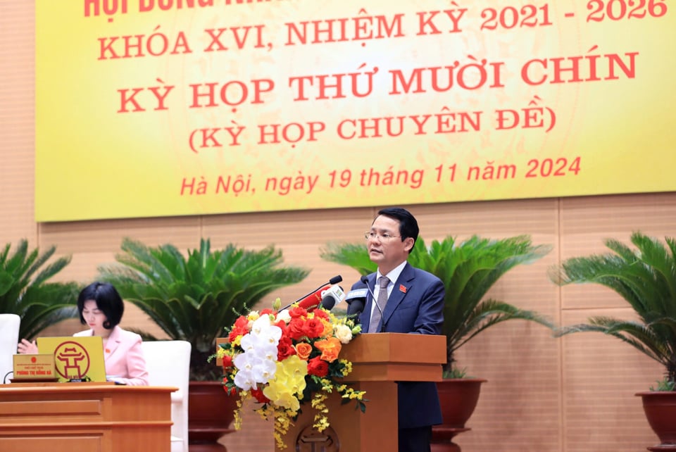 Vice Chairman of Hanoi People's Council Pham Qui Tien reported to ask for opinions from City People's Council delegates to approve the meeting agenda.