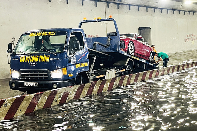 Fuerte lluvia por la noche, muchos vehículos parados y tirados en el suelo