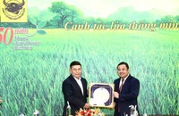 Lao National Assembly Chairman Xaysomphone Phomvihane presents a souvenir to Vinachem Chairman Phung Quang Hiep.