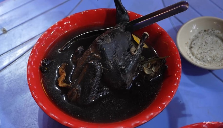 Luke mange du poulet noir ou du poulet noir mijoté avec des herbes chinoises dans la rue Hang Cot, à Hanoi. Photo : extrait du clip