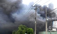 Un énorme incendie se déclare dans un atelier de menuiserie de 3 000 m2 à Binh Duong, avec de la fumée noire recouvrant la zone.