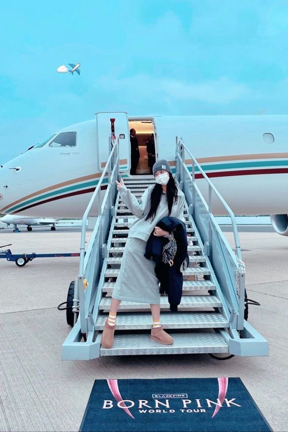 Jisoo zeigt ein Foto von sich, wie sie aus einem Flugzeug der Korean Air steigt und von einem Teppich mit der Aufschrift „Born Pink“ begrüßt wird.