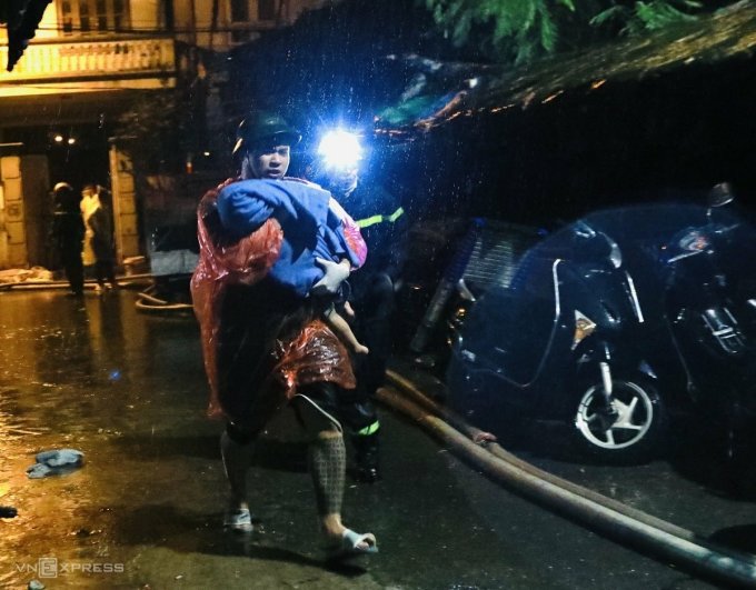 L'homme tenait l'enfant enveloppé dans une fine couverture et courut vers la civière, encourageant continuellement son enfant à continuer, tôt le matin du 13 septembre. Photo : Pham Chieu