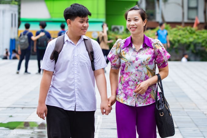 Candidates and their mothers come to complete procedures for the 10th grade exam at Tran Duy Hung Secondary School on the morning of June 9. Photo: Tung Dinh