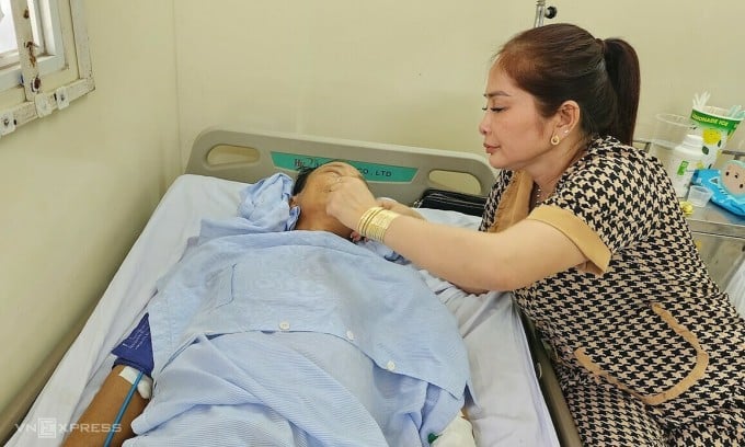 Ms. Quyen takes care of her husband lying on a hospital bed at Le Van Thinh Hospital after being taken to the emergency room by a traffic police car on the afternoon of February 14. Photo: Dinh Van