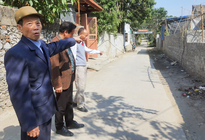 Ông Nguyễn Văn Quýnh (đầu tiên bên trái) và ông Nguyễn Văn Nhật (áo len gile xám) đứng tại con đường hai ông hiến đất để mở rộng. Ảnh: Võ Hải