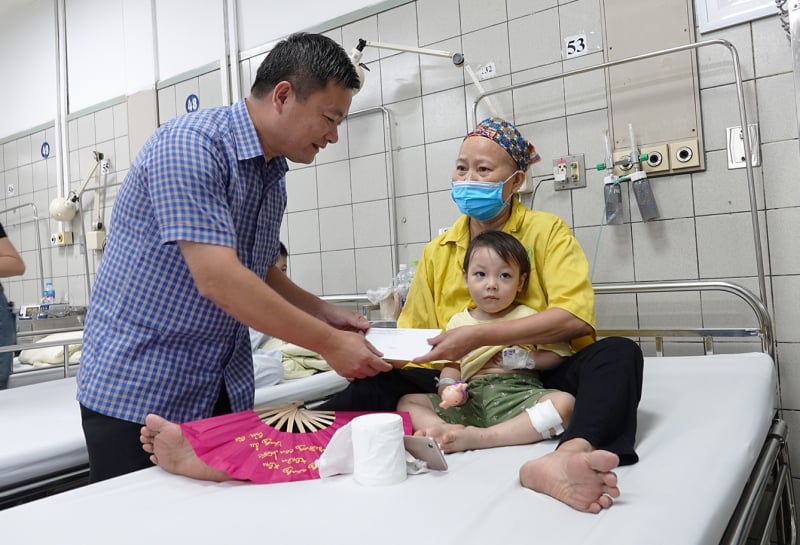 El Sr. To Duc, Director del Departamento de Protección Social, visitó y entregó regalos a los niños enfermos que estaban recibiendo atención y tratamiento en el Hospital Bach Mai. Foto: XQ