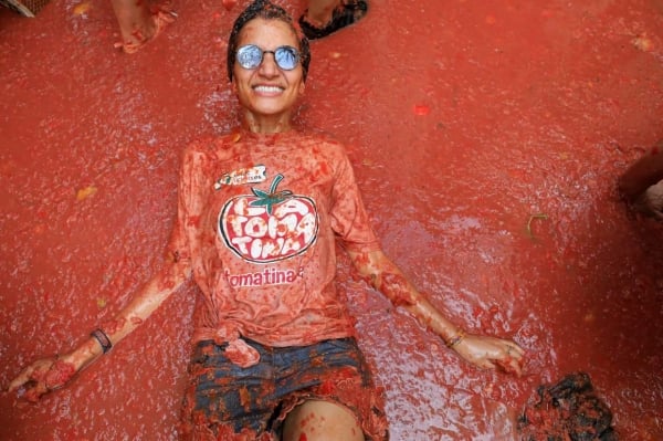 ผู้เข้าร่วมงานเทศกาล La Tomatina ขว้างมะเขือเทศ ทำให้เมืองทางตะวันออกของสเปนกลายเป็นสีแดง