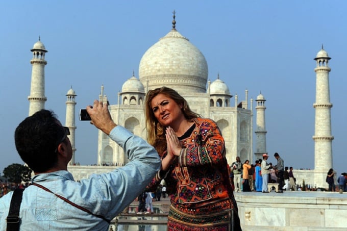 អ្នក​ទេសចរ​ឈរ​នៅ​មុខ​ Taj Mahal ក្នុង​ប្រទេស​ឥណ្ឌា។ រូបថត៖ Kanigas