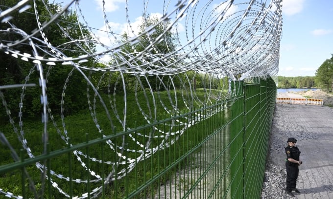 Des agents de sécurité finlandais montent la garde à la barrière frontalière avec la Russie à Pelkola, le 30 mai. Photo : Reuters