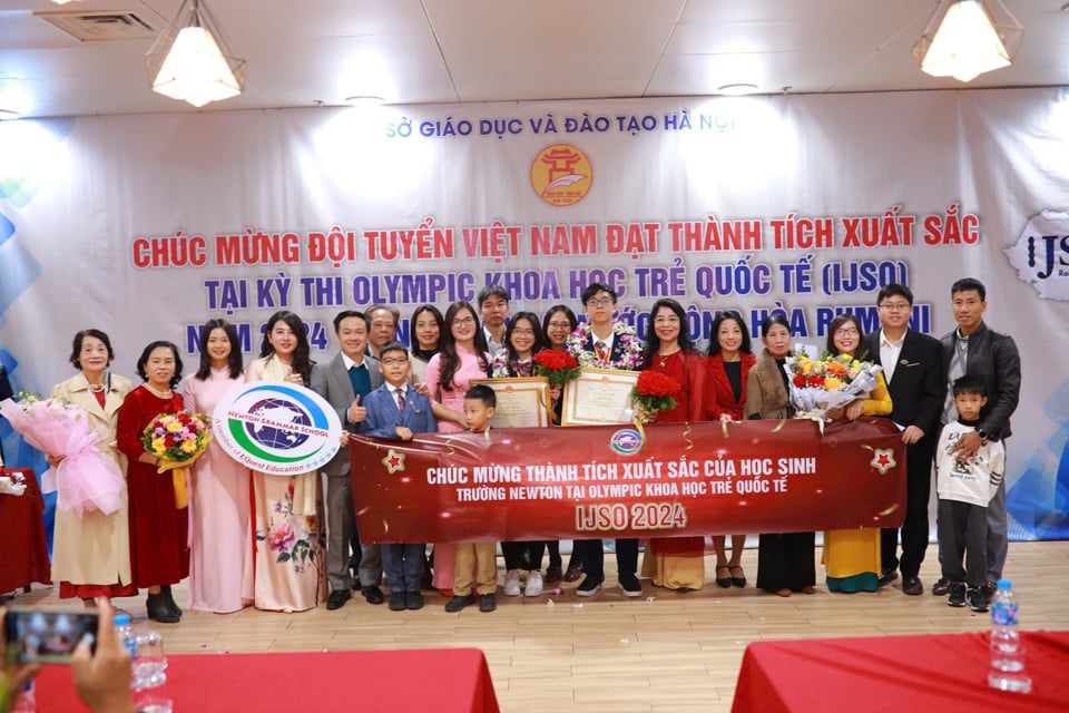 La junta directiva, los maestros de la escuela secundaria y preparatoria Newton y las familias de Vuong Ha Chi y Vu Nhat Long, dos estudiantes de Newton que ganaron excelentemente medallas de plata.