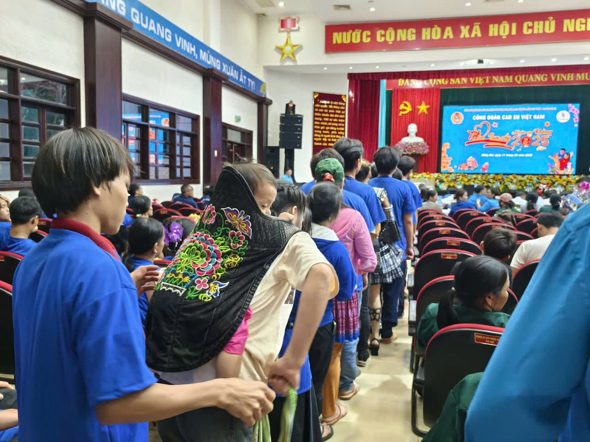 Rubber workers carry their children to receive Tet gifts