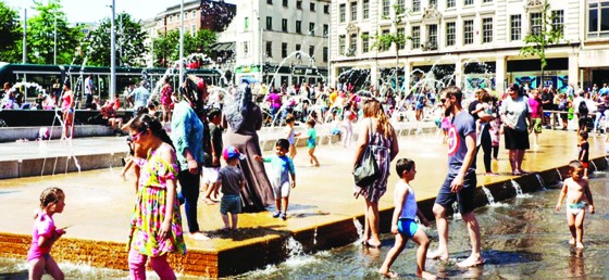 Los niños juegan en el agua durante una ola de calor inusual en Europa. Foto: The Guardian