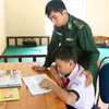 Les officiers et les soldats du poste frontière international de Le Thanh s'efforcent d'éduquer les enfants. (Photo : Hong Diep/VNA)