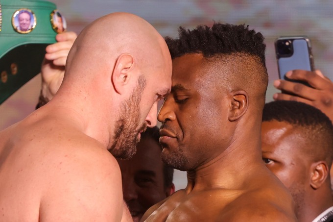 Fury (trái) và Ngannou chạm mặt trong buổi cân nặng ngày 27/12 tại Riyadh, Saudi Arabia. Ảnh: AFP