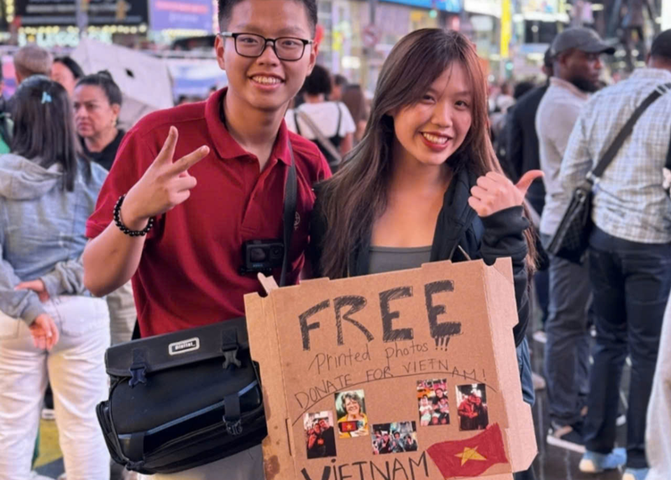 Pham Khanh Toan et des jeunes réalisent le projet caritatif « Photographie gratuite, don pour soutenir les Vietnamiens touchés par les inondations » à Times Square (USA). Photo fournie par la famille