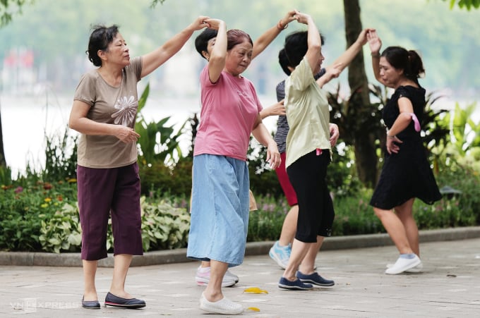 Des personnes âgées à Hanoi se détendent au bord du lac Hoan Kiem, août 2023. Photo : Ngoc Thanh