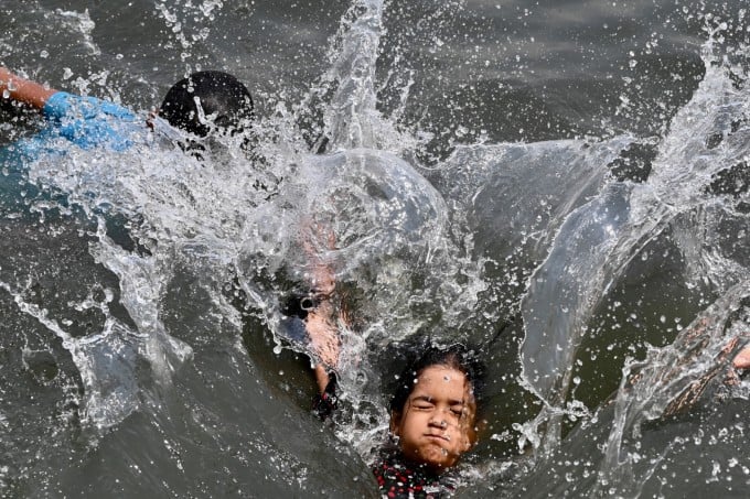 Trẻ em bơi lội trên sông Buriganga ở thủ đô Dhaka, Bangladesh, ngày 6/6 để tránh nóng. Ảnh: AFP