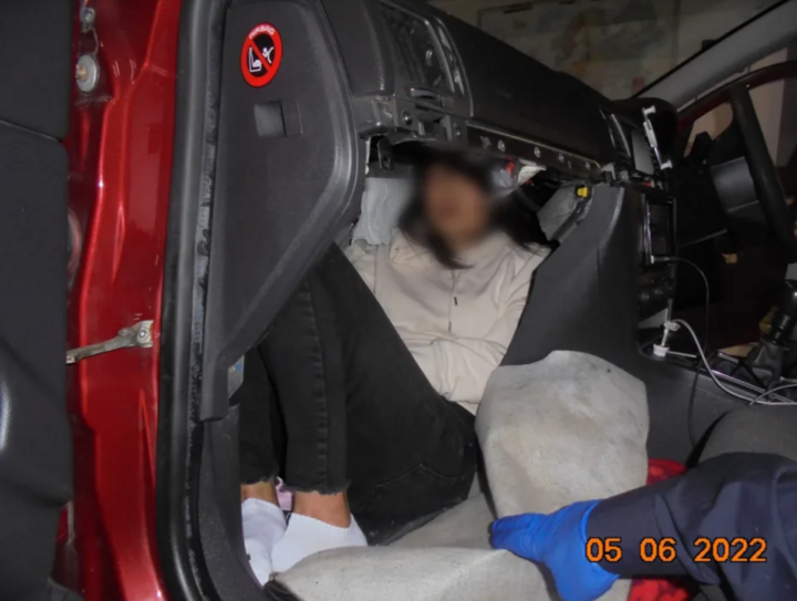 Image d'une femme vietnamienne se cachant dans un petit compartiment conçu sous la boîte à gants d'une voiture Vauxhall Vectra. (Photo : Couronne)