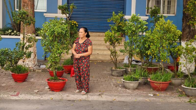 Ms. Nguyen Thi Y, stood inviting customers to buy kumquat pots for 200,000 VND/pot, but the customers shook their heads and walked away. Photo: Hoang Loc.