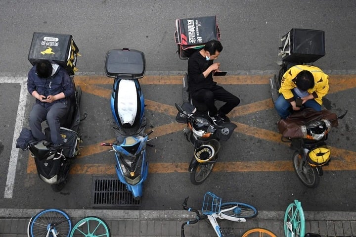 Nhân viên giao đồ ăn chờ lấy đơn bên ngoài một nhà hàng ở Bắc Kinh, Trung Quốc. (Ảnh: Getty Images)