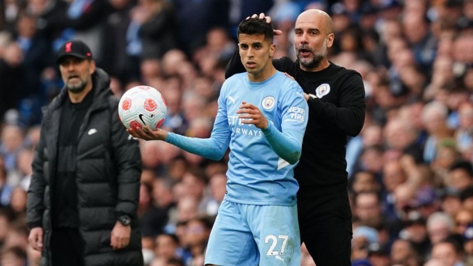 Trainer Guardiola und Cancelo in einem Spiel zwischen Man City und Liverpool in der Premier League. Foto: DPA