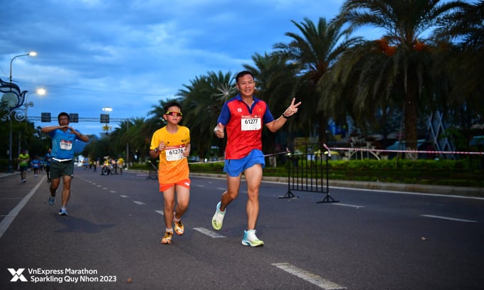 Coach Tran Van Sy and his son on the VnExpress Marathon Sparkling Quy Nhon 2023 running track. Photo: VM