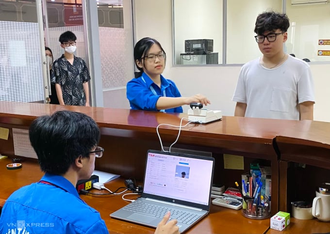 Les candidats doivent scanner leur carte d’identité et prendre des photos d’identité avant d’entrer dans la salle d’examen. Photo : Duong Tam