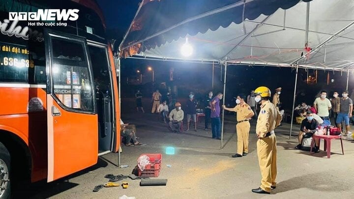 Traffic Police check goods and number of passengers on the bus. (Photo: Xuan Tien)