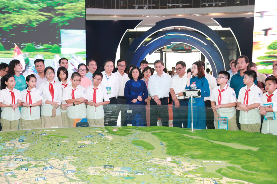 Secretary of the City Party Committee Bui Thi Minh Hoai and other city leaders, teachers and students listened to the explanation at the exhibition.