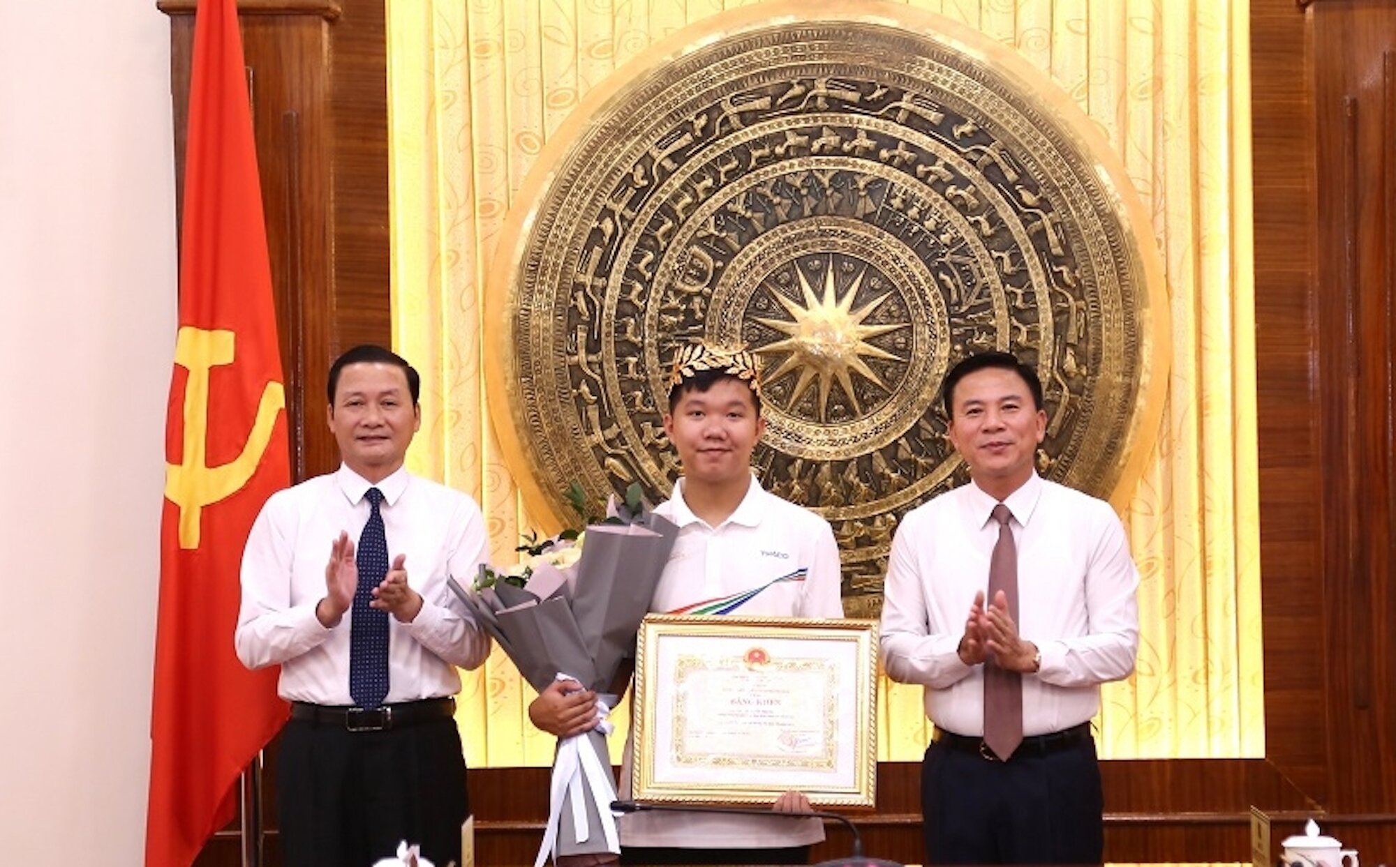 Le secrétaire du Parti provincial de Thanh Hoa, Do Trong Hung (à droite) et le président du Comité populaire provincial, Do Minh Tuan (à gauche), ont remis un certificat de mérite à Le Xuan Manh.