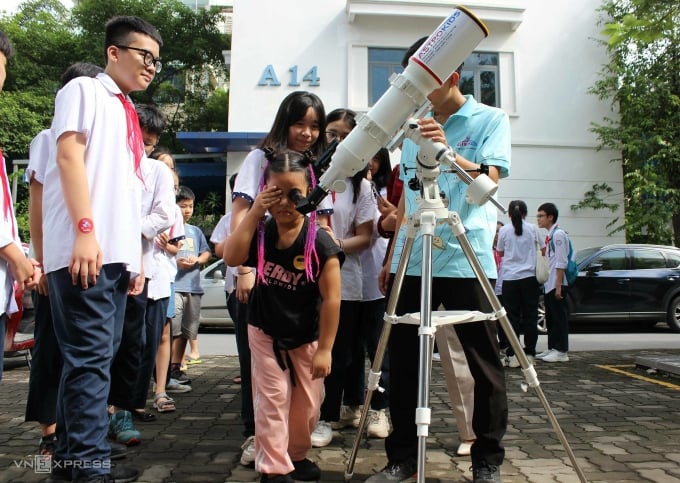 生徒たちは望遠鏡を通して太陽を観察します。写真: NQ