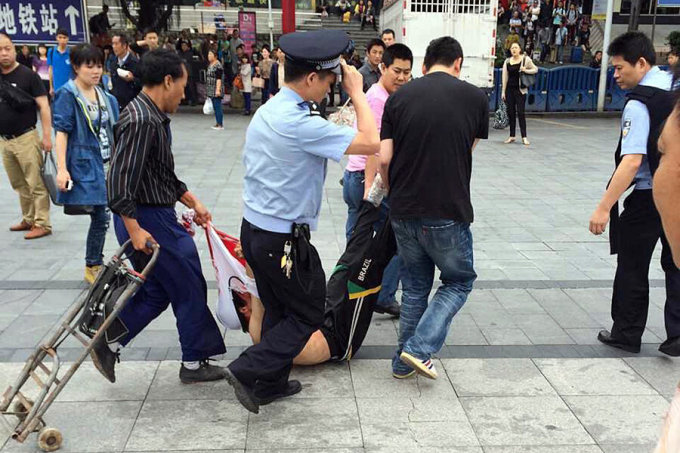 Police and residents restrain a stabbing suspect at a train station in Guangzhou, Guangdong province in 2014. Photo: AP