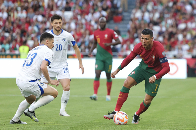 Ronaldo (phải) im lặng trước hàng thủ Bosnia & Herzegovina trong trận đấu tối 17/6. Ảnh: EPA